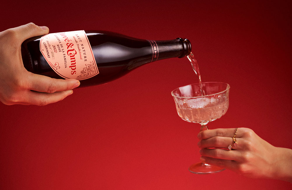 Bottle of Juvé y Camps Reserva de la Familia Rosé sparkling wine being served in a glass